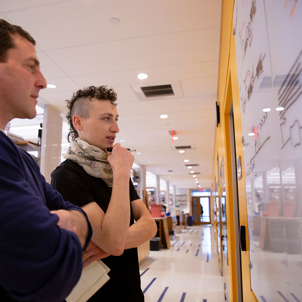 Leighton Core, assistant professor of molecular and cell biology, discusses a project with Ph.D. student Geno Villafano in the Engineering & Science Building