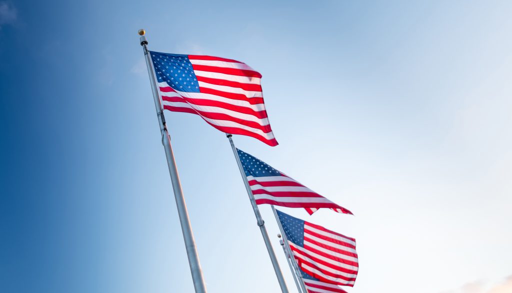 Picture of 3 American flags waving in the air.